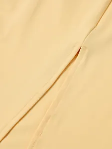 Détail de la couture précise et texture côtelée sur la fente de la robe beige
