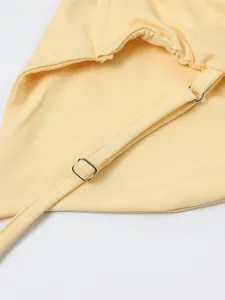Détail des bretelles réglables et de la texture côtelée sur la robe moulante jaune