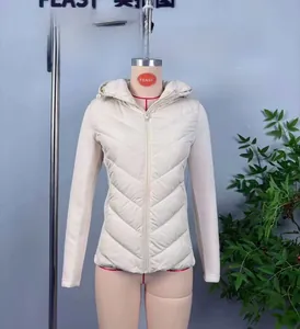 Detail of beige quilted hooded jacket with knit sleeve stitching and zipper closure
