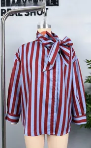Detail of red and blue vertical striped shirt featuring a large pussy-bow tie neckline