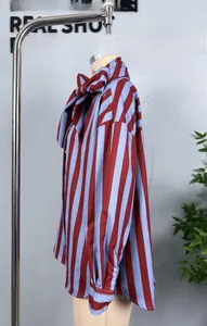 Close-up of striped long-sleeve shirt featuring an elegant oversized bow tie neckline