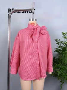 Detailed view of red and white striped blouse featuring a stylish pussy-bow tie neckline
