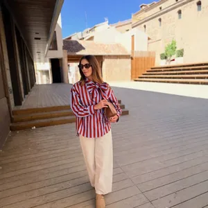 Women's striped long sleeve shirt with large bow tie and beige wide-leg pants set