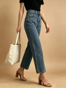 Detail of high waist straight blue denim jeans featuring washed craft and metal button