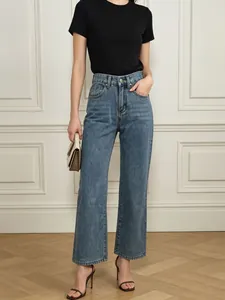 Detail of high-waisted blue straight leg denim jeans paired with a casual black tee