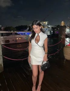 Close-up of white mini dress with black piping and keyhole neckline on yacht