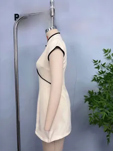 Detail view of sleeveless qipao dress with black contrast piping and mandarin collar