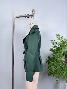 Side view of dark green cropped windbreaker jacket with shoulder tabs and waist belt