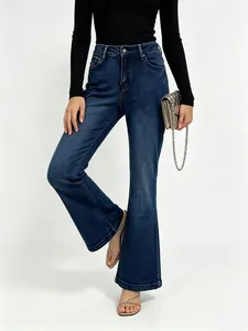 Detail of dark blue flare jeans with natural whiskers and high waist stretchy denim fit