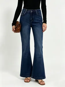 Detail of high waisted flared denim jeans in dark blue with classic five-pocket design