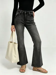 Detail of high-waisted flared jeans with vintage washed grey finish and slim fit texture