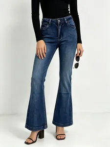 Detail of high waist blue flare jeans with vintage wash and slim fit denim texture