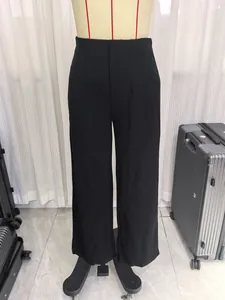 Detailed view of women's black high-waisted wide-leg trousers on a mannequin