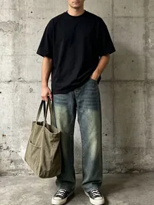 Jeans uomo dritti lavaggio retrò con maglietta nera e look stile urbano vintage