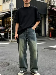 Dettaglio di jeans uomo larghi lavati vintage con sbiadimento retrò e effetto usurato