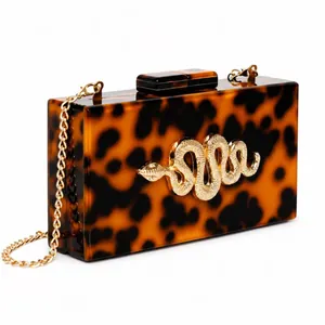 Tortoiseshell acrylic clutch bag with golden snake relief and chain strap for evening