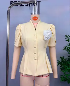 Détail de blazer jaune clair à manches courtes avec rose artisanale et coupe cintrée