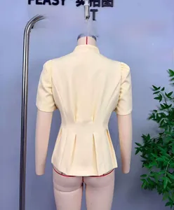 Détail d'un chemisier jaune clair à manches bouffantes et taille plissée cintrée