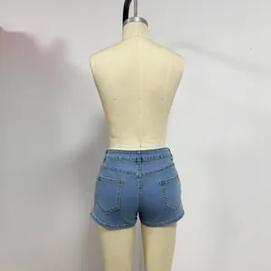 Detail view of high-waisted light blue denim shorts with functional back pockets