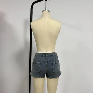 Detail view of the back pockets and washed texture on dark blue denim shorts