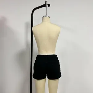 Rear view of black low-rise denim shorts with back pockets on a mannequin