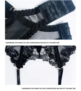Détail de la broderie en dentelle florale noire et de la fermeture à agrafes au dos