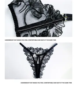 Détail d'un string en dentelle noire brodée avec fleurs et boucles en métal doré