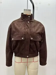 Détail de la veste aviateur marron foncé en daim avec poches à rabat et boutons-pression en métal