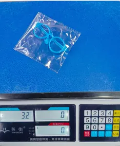 Blue plastic pet glasses frame on digital scale showing a lightweight 3.2g measurement