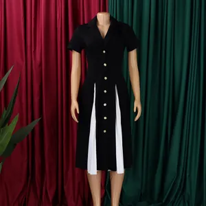 Détail de la robe noire avec des plis blancs contrastés et des boutons dorés