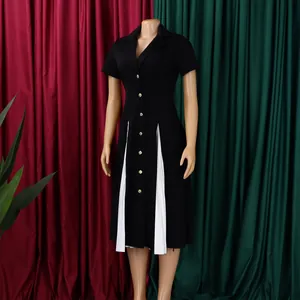 Détail d'une robe noire avec boutons dorés et empiècements plissés blancs