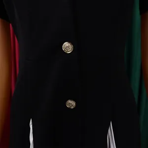Gros plan sur les boutons dorés gaufrés d'un blazer noir professionnel texturé