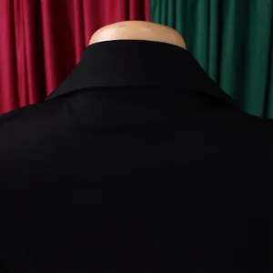 Gros plan du col arrière d'un manteau noir montrant la texture fine du tissu