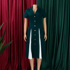 Détail de la robe vert foncé montrant les plis blancs et le col à revers