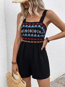 Detailed close-up of ethnic floral embroidery on a black summer vacation romper