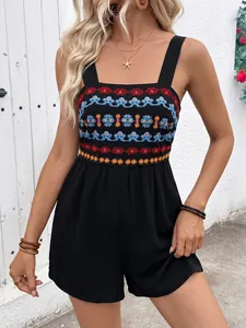 Detailed view of colorful ethnic embroidery on a black sleeveless summer romper