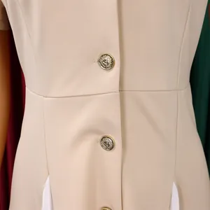 Gros plan du blazer beige avec boutons dorés en relief et coutures contrastées