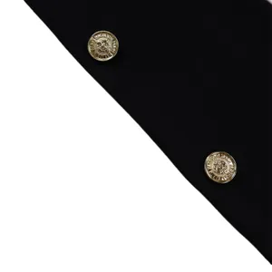Détail de boutons dorés gaufrés avec motif de blason sur un blazer noir élégant