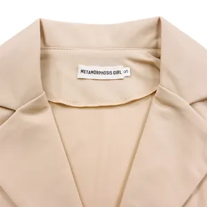 Détail du col d'un blazer beige avec étiquette de marque et indication de taille S
