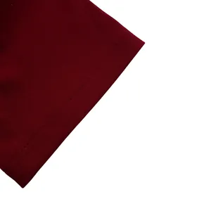 Gros plan sur le tissu tricoté bordeaux montrant les détails de couture plate double