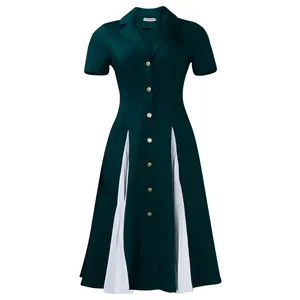 Détail de la robe vert forêt avec empiècements plissés blancs et boutons dorés