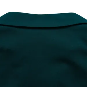 Gros plan du col polo en maille vert foncé montrant les coutures et la texture du tissu
