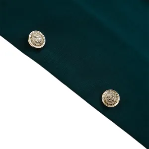 Détail de boutons dorés à tête de lion sur tissu sergé vert foncé de blazer