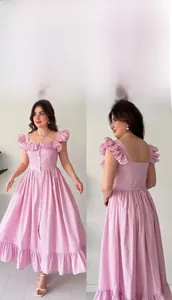Détails d'une robe mi-longue à rayures roses et blanches avec volants et boutons devant