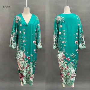 Détail d'une robe longue verte à col en V avec imprimé floral et manches longues