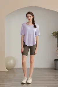 Front view of a light purple yoga t-shirt with cut-out details and green cycling shorts