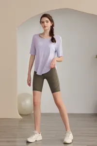 Detail of light purple yoga top with asymmetric neckline cutout and bike shorts