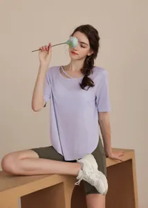 Detail of lavender yoga t-shirt with crossover neckline cutout and green shorts