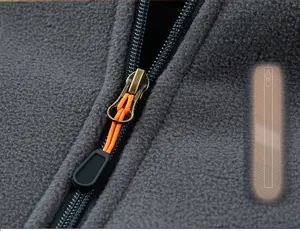 Detail of durable metal zipper with orange puller on gray fleece vest jacket