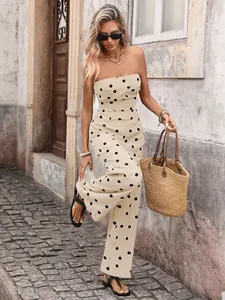 Close-up of beige polka dot strapless jumpsuit with wide-leg cut and summer straw bag